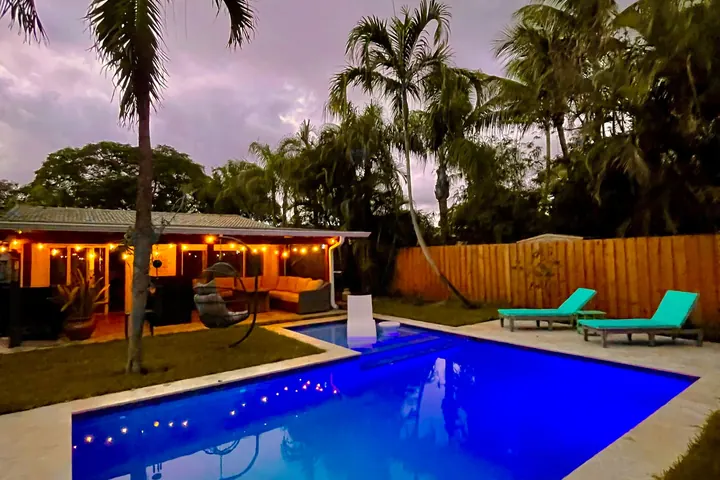 The pool-and-palm backyard at Turtle Nest Bungalow at dusk