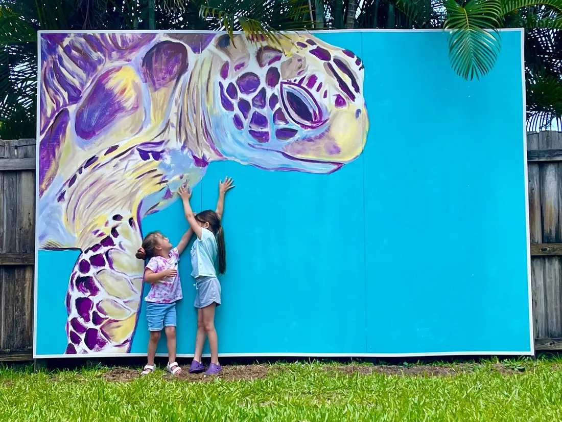 Large hand-painted sea-turtle mural on the backyard wall beside the pool