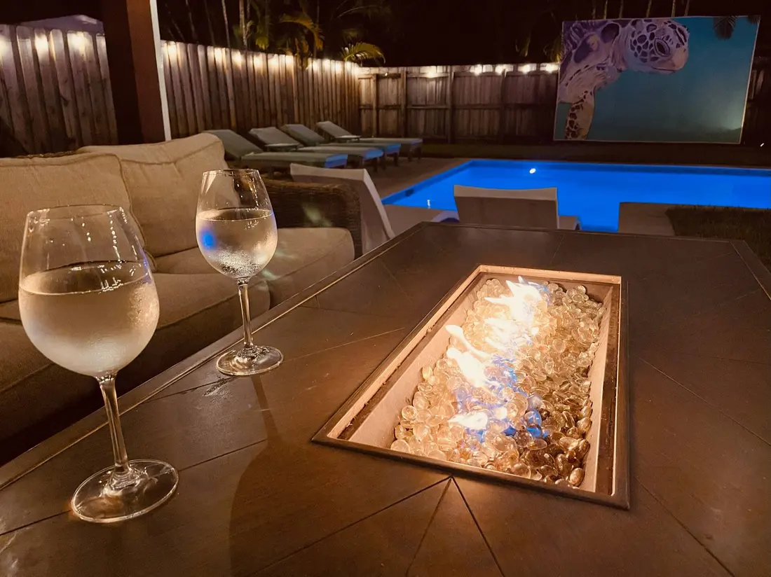 Glass of wine beside the lit fire pit at night