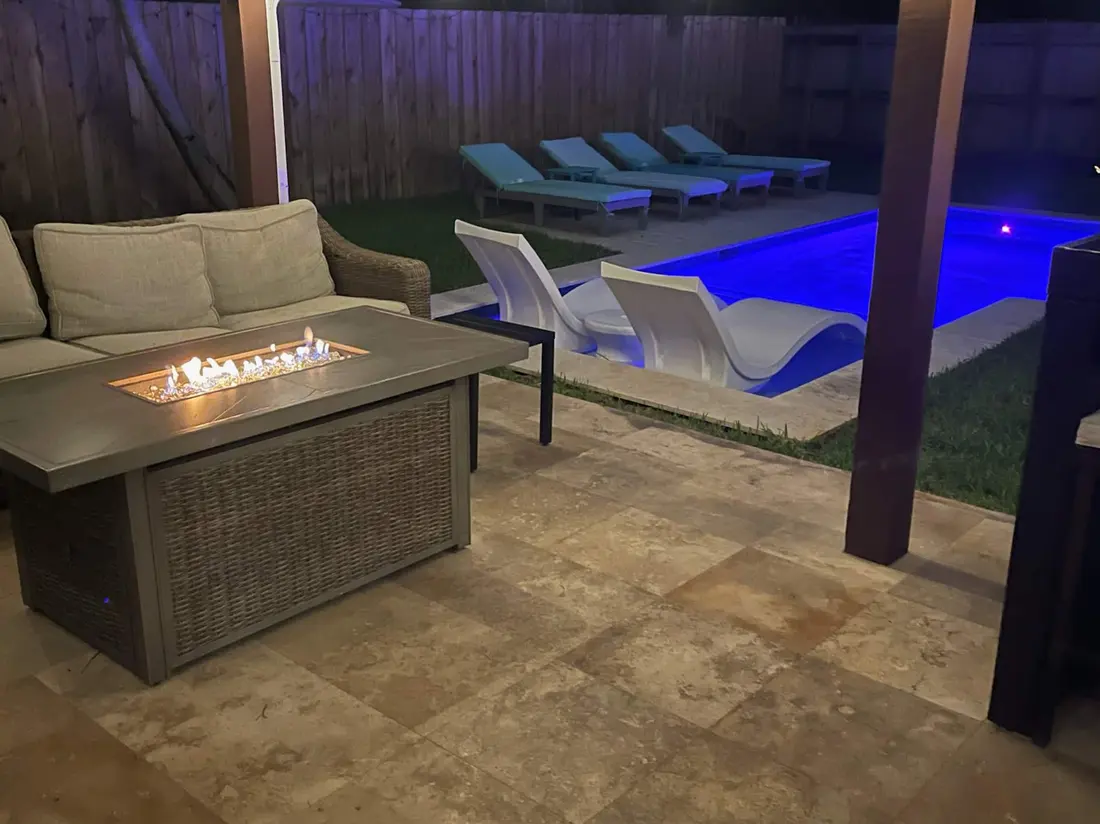 The backyard, pool and fire pit lit at night