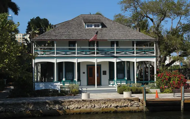 Historic Stranahan House Museum: the historic two-story wooden Stranahan House Museum on the waterfront viewed across the New River under a clear sky