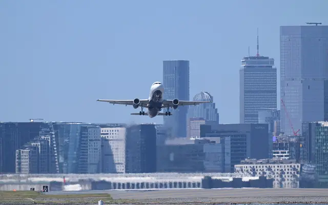 A JetBlue Airbus A320 departing Boston Logan with the Boston skyline behind