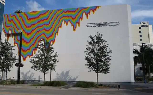 Exterior of the NSU Art Museum Fort Lauderdale building featuring a colorful dripping rainbow mural on its white modernist wall