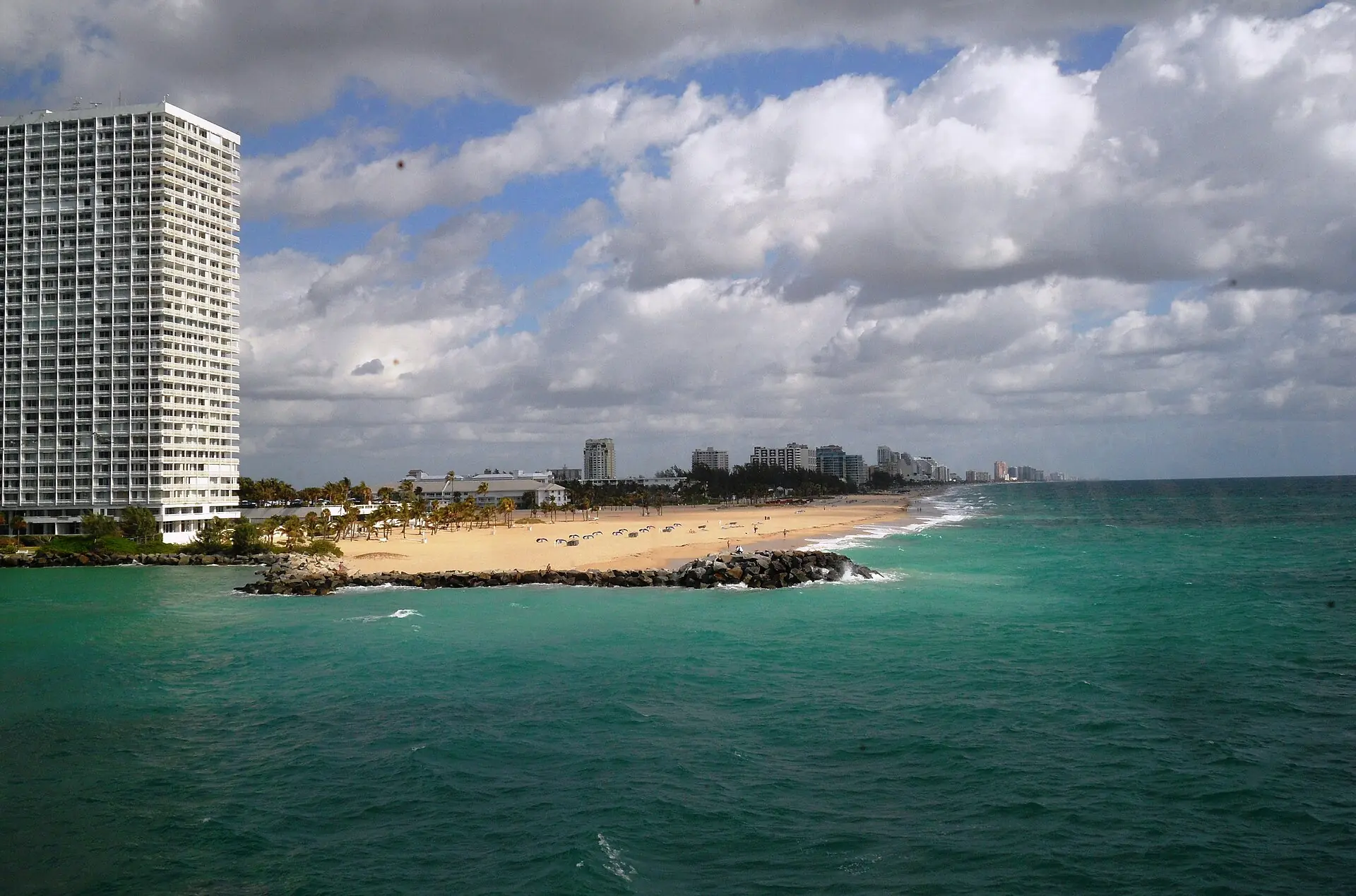 A distant elevated view of the Fort Lauderdale beach and coastal high-rises from the Port Everglades inlet jetty