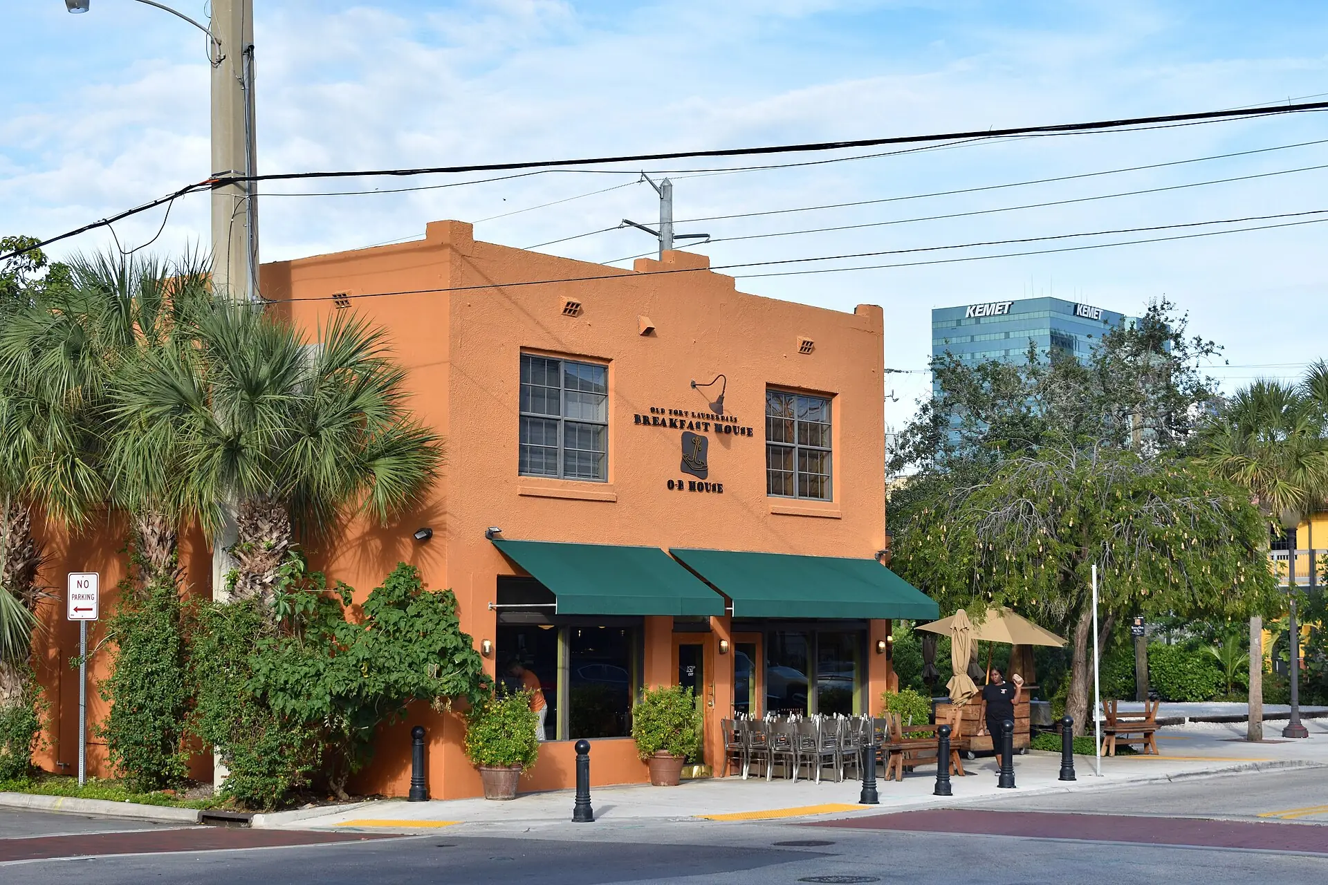Old Fort Lauderdale Breakfast House restaurant with an orange facade, green awnings, and outdoor patio seating
