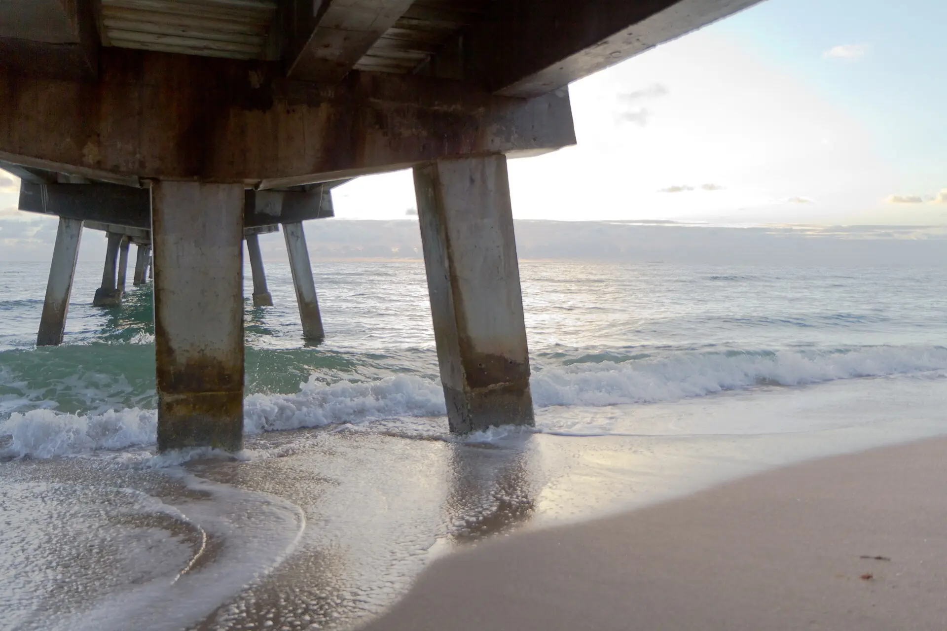 Lauderdale-by-the-Sea: waves washing under the fishing pier at sunrise
