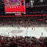 Interior view of an ice hockey game taking place inside the Amerant Bank Arena with spectators and the large central scoreboard