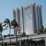 Sea Experience / Bahia Mar Marina: exterior of the Bahia Mar hotel tower framed by palm trees and flags in Fort Lauderdale