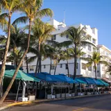 Lummus Park: art Deco hotels, palm trees, and outdoor dining umbrellas along Ocean Drive in South Beach, Miami Beach