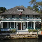 The historic two-story wooden Stranahan House Museum on the waterfront viewed across the New River under a clear sky
