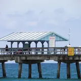 Anglin's Fishing Pier: people on the pier and its covered shelter at Lauderdale-by-the-Sea